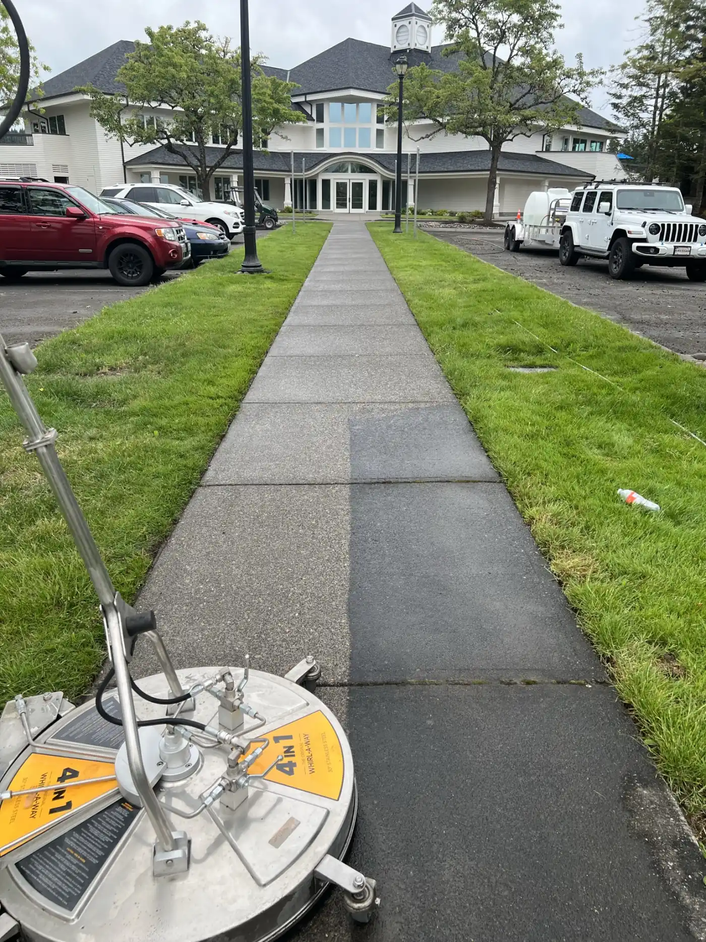 A clubhouse walkway mid-clean, cleaned slabs bright against the dark untouched ones