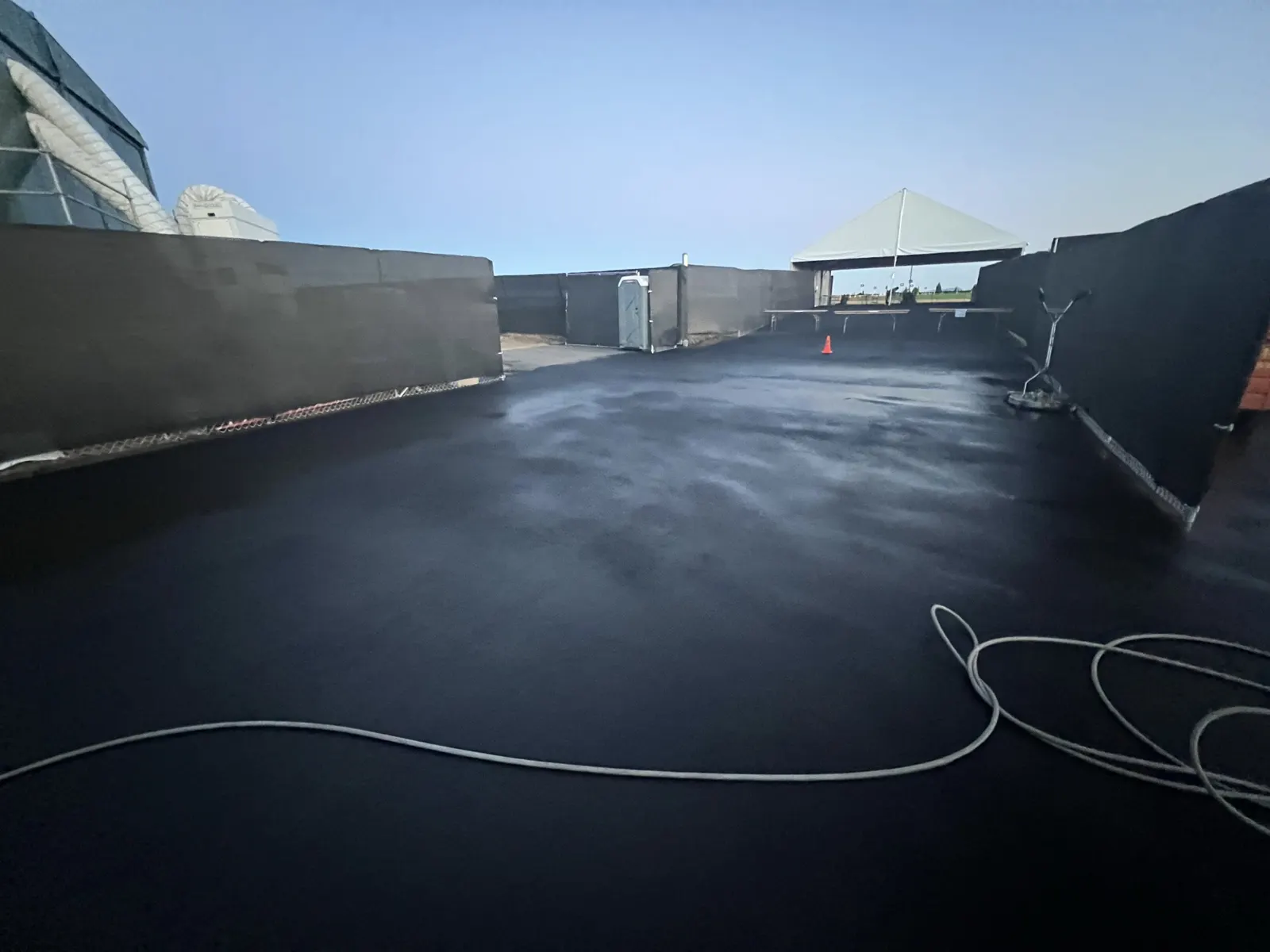 Black event flooring rinsed and gleaming inside a temporary structure